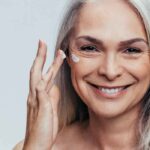 Mujer aplicando crema en el contorno de ojos y labios