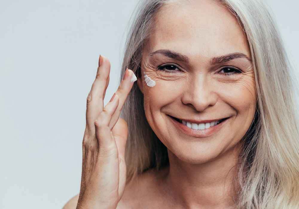 Mujer aplicando crema en el contorno de ojos y labios