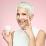 Mujer aplicando crema hidratante en su rostro