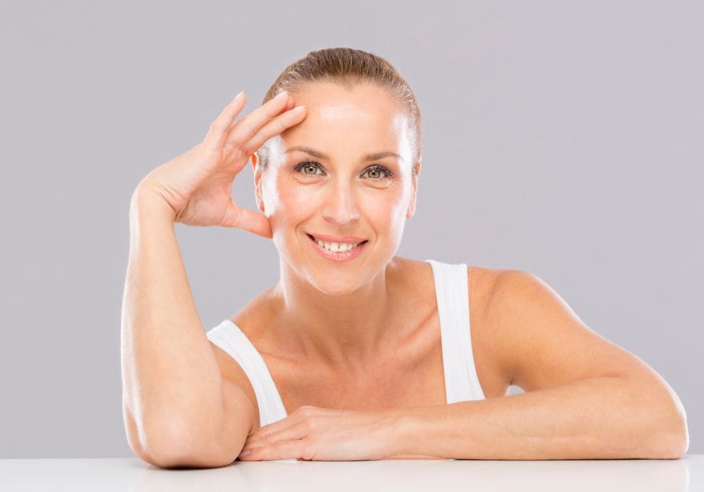 Imagen de una mujer cuidando su piel con productos faciales